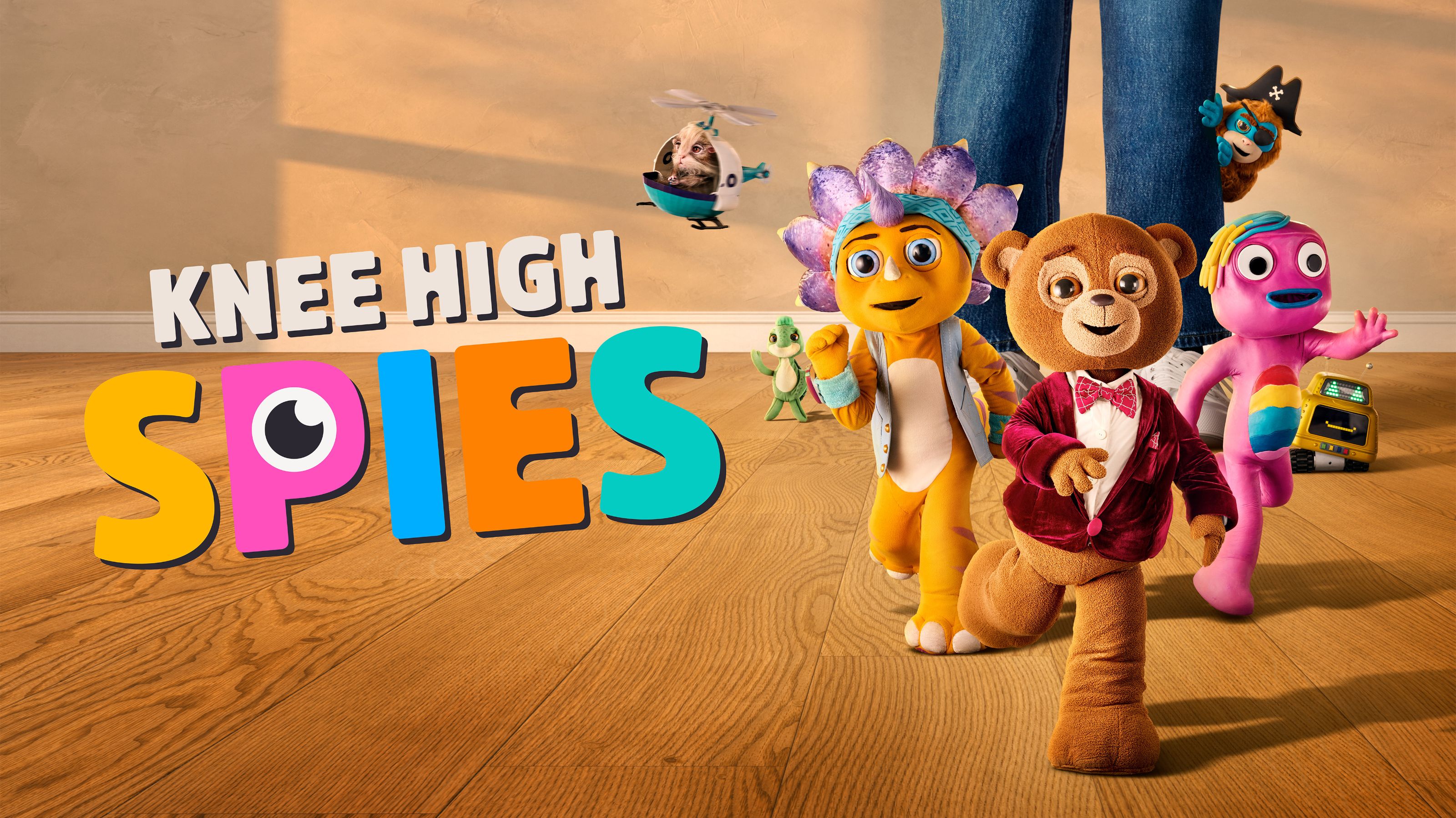 Colorful animated characters, including a bear in a tuxedo, a flower-like figure, and a vibrant pink character, walk confidently across a wooden floor. Above them, a small helicopter with an animal is flying, and the characters are surrounded by playful elements, with the title