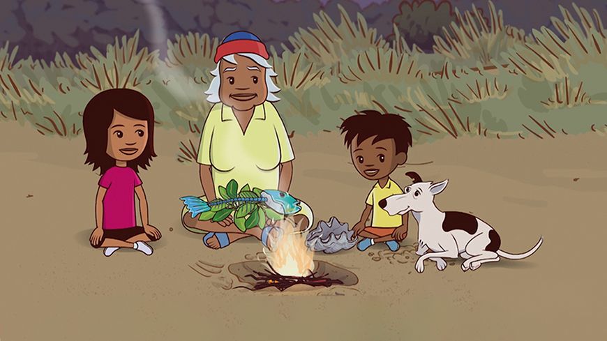 Two children, a girl and a boy, sit beside an elderly man in a yellow shirt, all smiling at each other. In front of them, a campfire crackles with flames, while a dog lays nearby. The girl holds a large fish and some leaves, suggesting they are preparing a meal outdoors. Lush greenery surrounds them in a twilight setting.