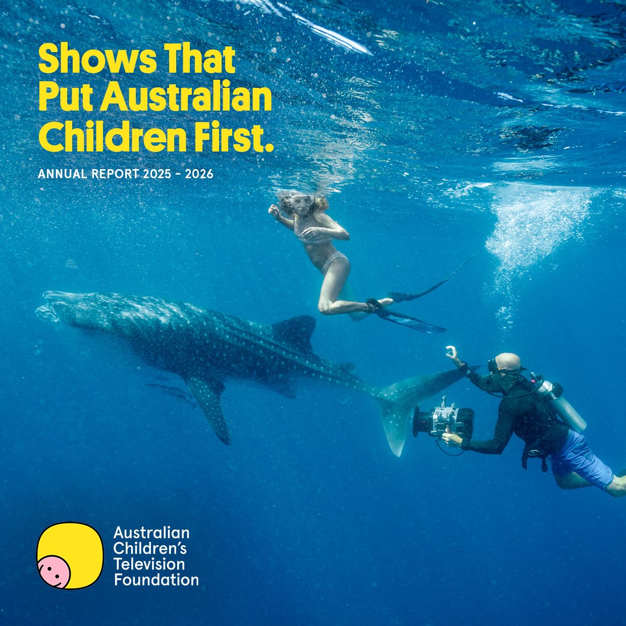 A diver captures footage of a woman swimming close to a whale shark in clear blue water. Above them, bold yellow text reads, "Shows That Put Australian Children First." along with a logo for the Australian Children's Television Foundation, indicating an annual report for 2025-2026.